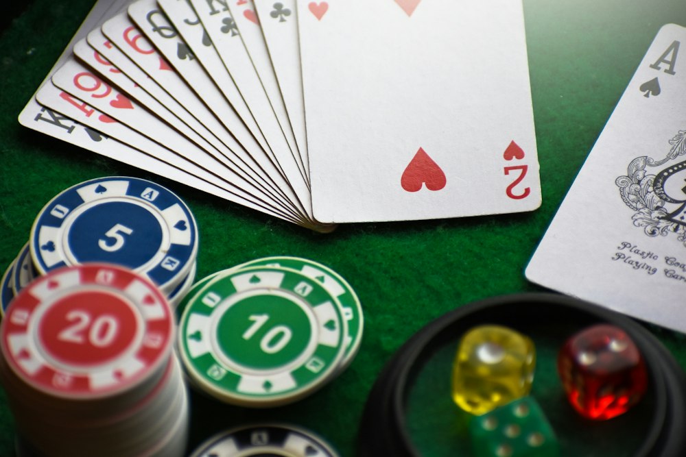Playing cards and colourful casino chips on a green table